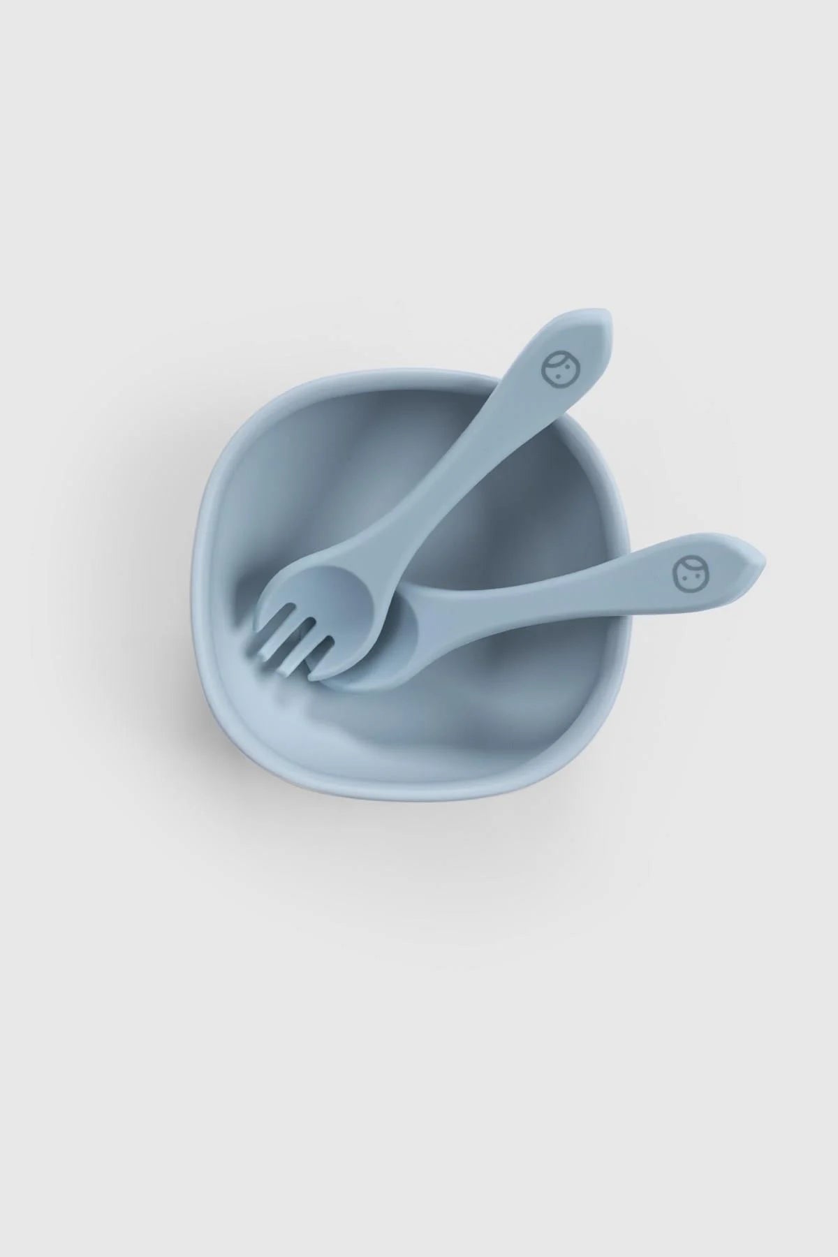 Silicone vacuum food plate and cutlery set in blue, featuring a bowl, fork, and spoon for easy baby self-feeding.