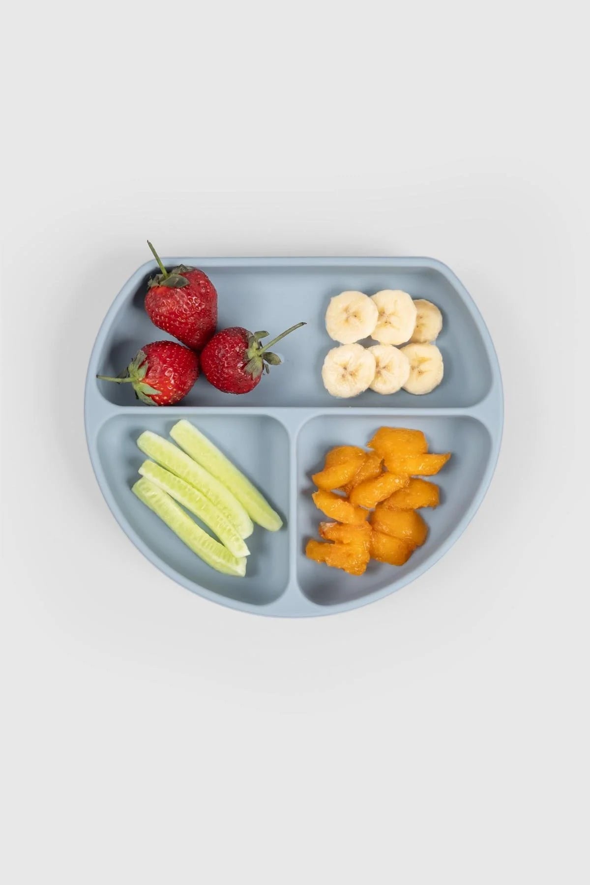 3-compartment blue baby feeding plate with lid holding strawberries, bananas, cucumber, and mango.