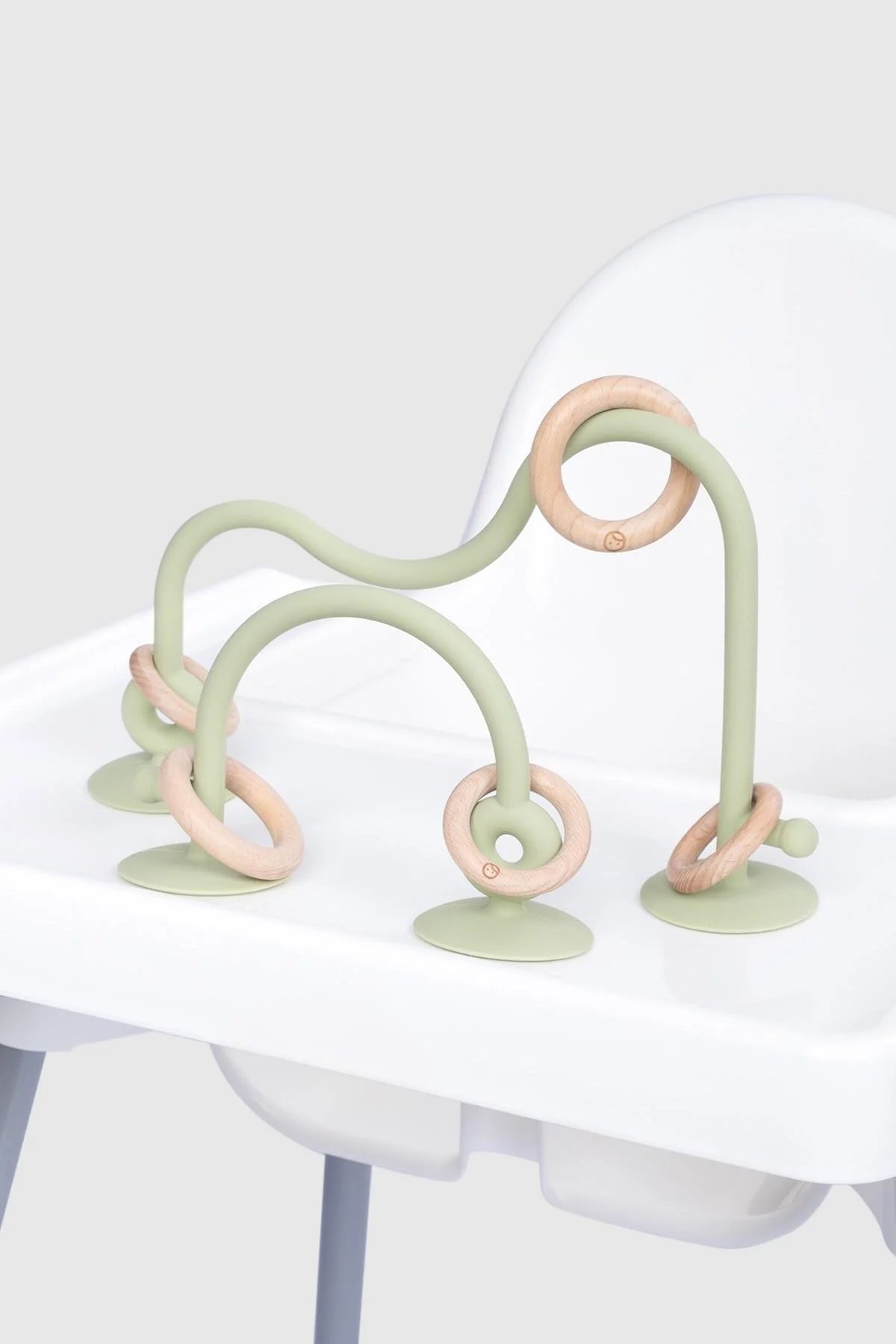 Silicone educational high chair toy in green, featuring playful loops and bamboo accents for baby and toddler learning.