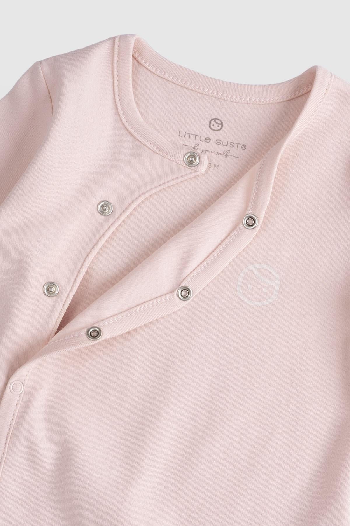 Close-up of a pink organic cotton baby sleepsuit with snaps by Little Gusto, soft and breathable for infants.