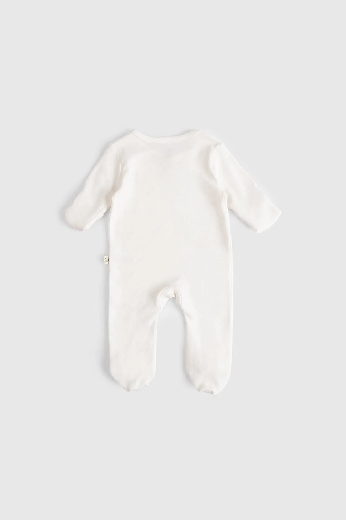 Back view of an organic cotton baby sleepsuit in white, showcasing its soft fabric and cozy design.