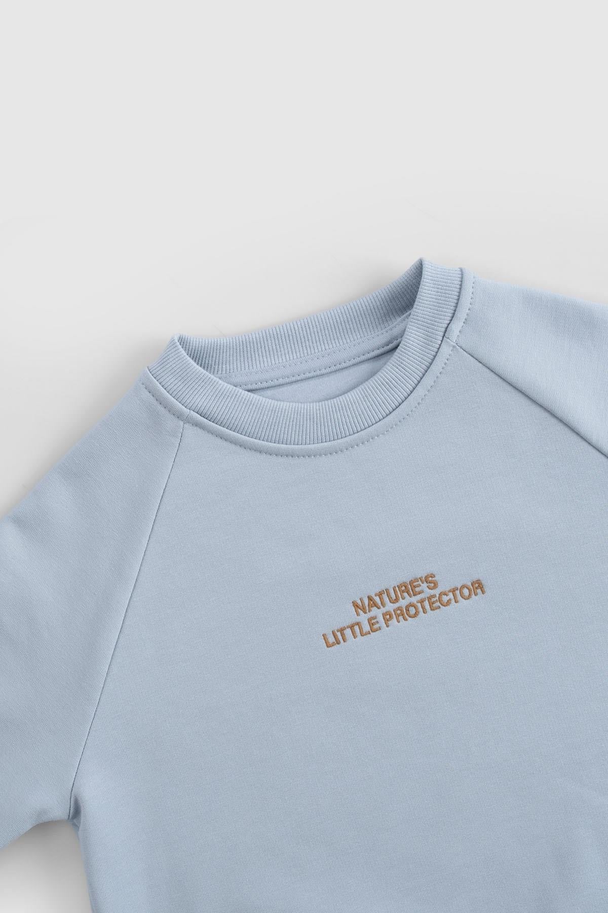 Organic cotton baby tracksuit set in blue with 'Nature's Little Protector' embroidery.