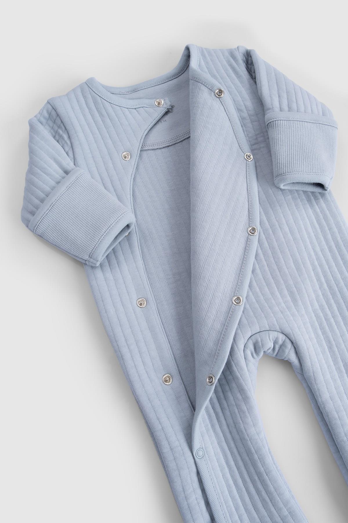Organic cotton quilted sleepsuit in soft blue, designed for baby comfort with snap buttons and ribbed cuffs.