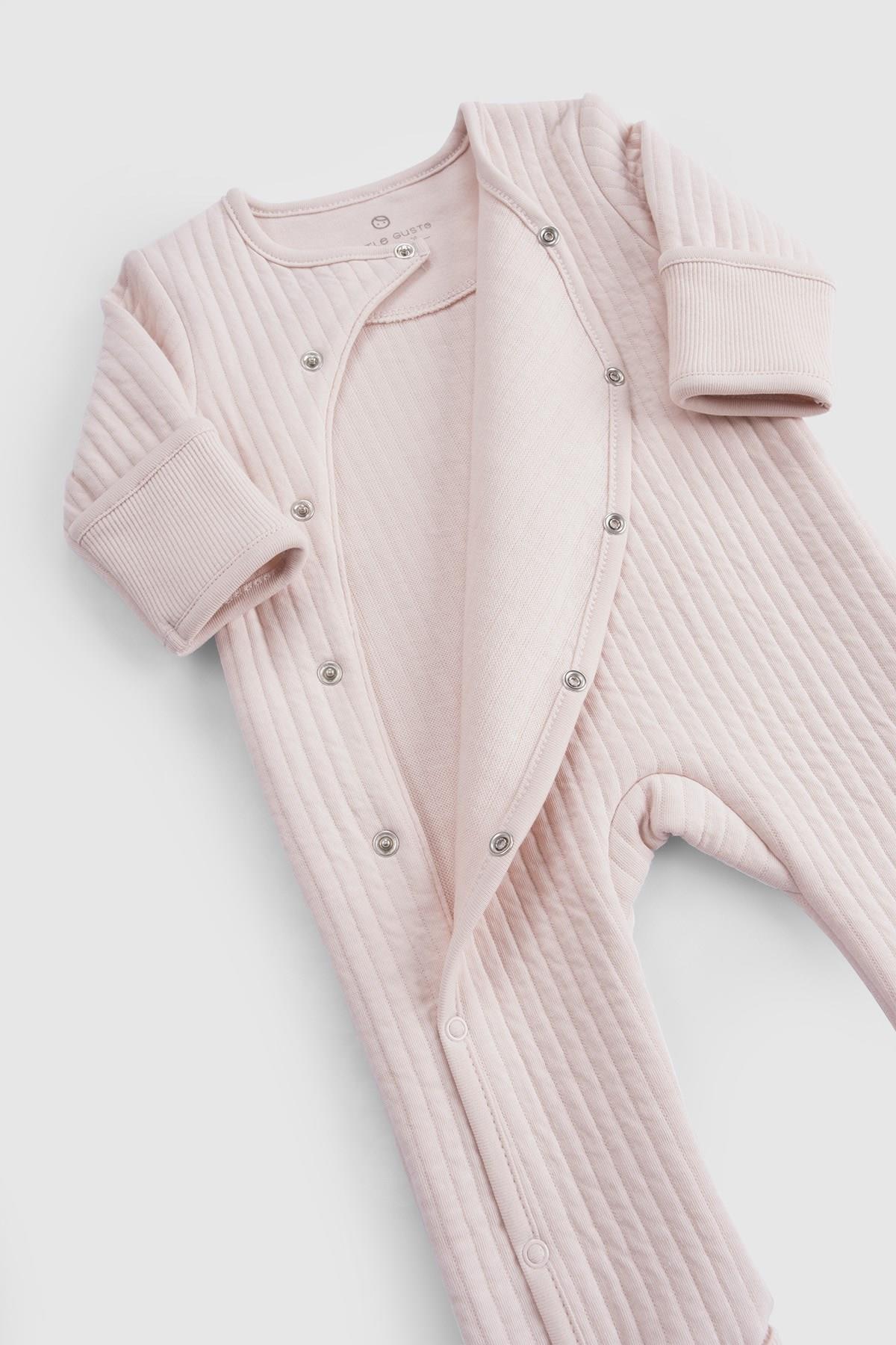Organic cotton quilted sleepsuit in pink, designed for baby comfort and warmth with snap closures and soft padding.