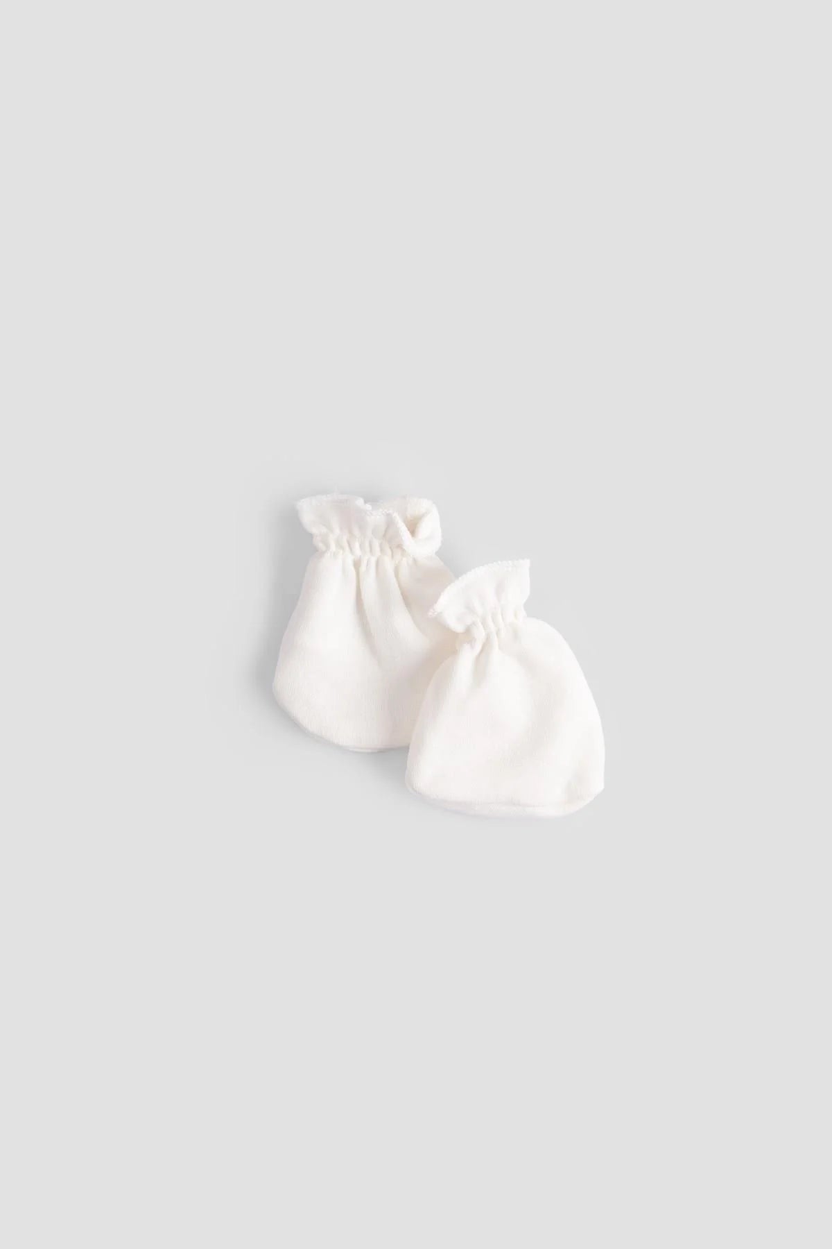 Organic cotton newborn mittens in white, perfect for keeping baby's hands warm and scratch-free.