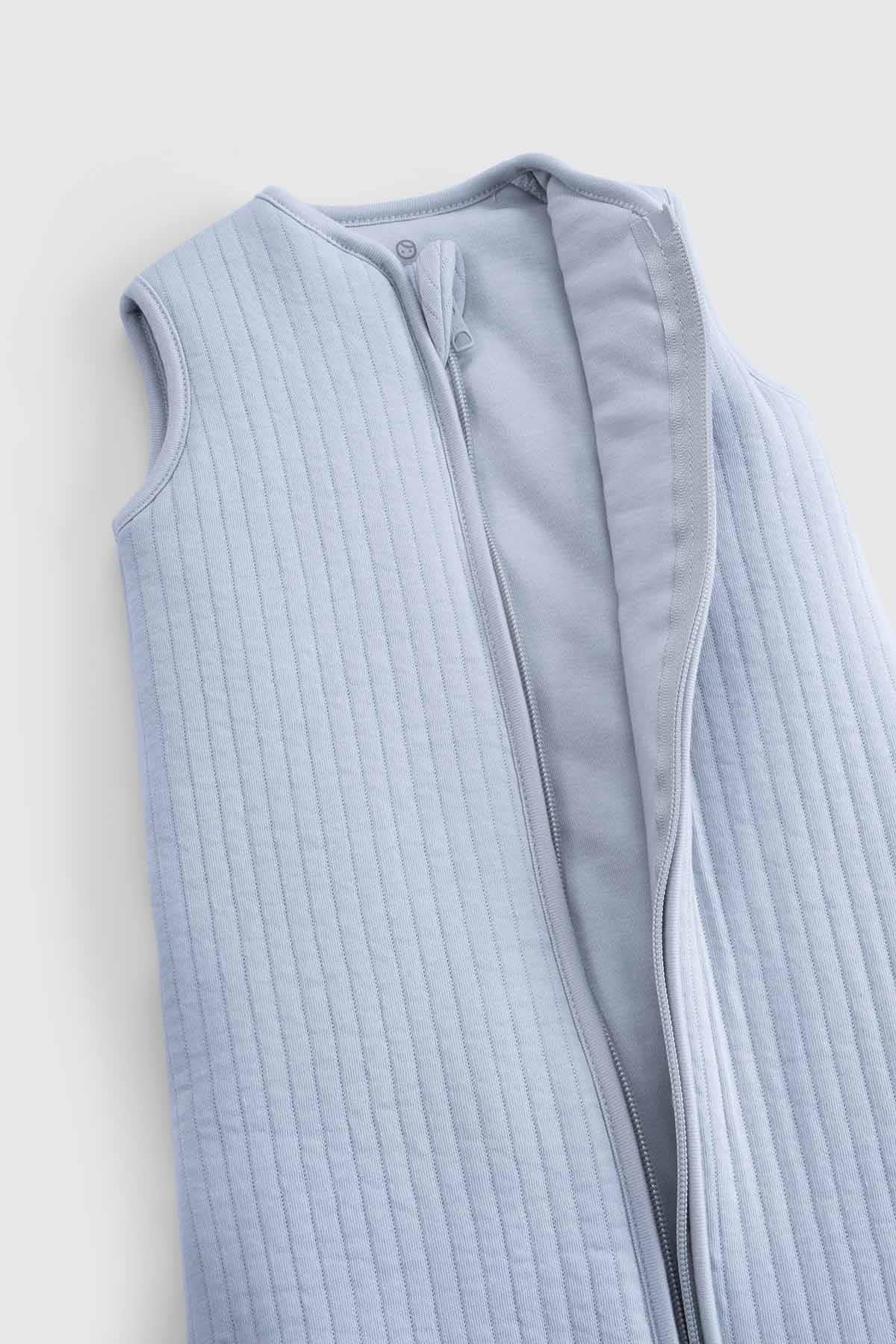 Soft blue organic cotton quilted sleeping bag, sleeveless design, perfect for baby's comfort and safety.