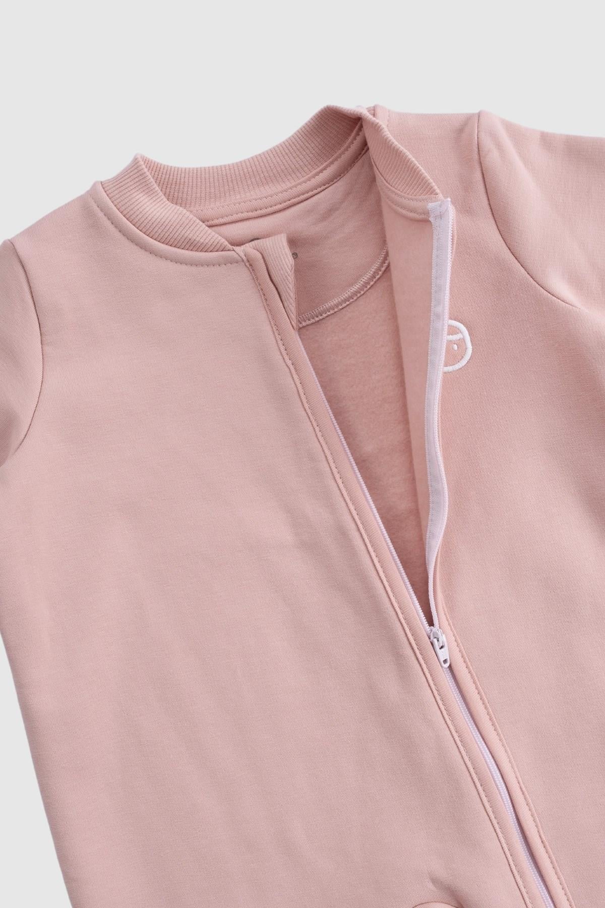 Close-up of the Little Gusto organic cotton zipped onesie in pink, showcasing fabric and zipper details.