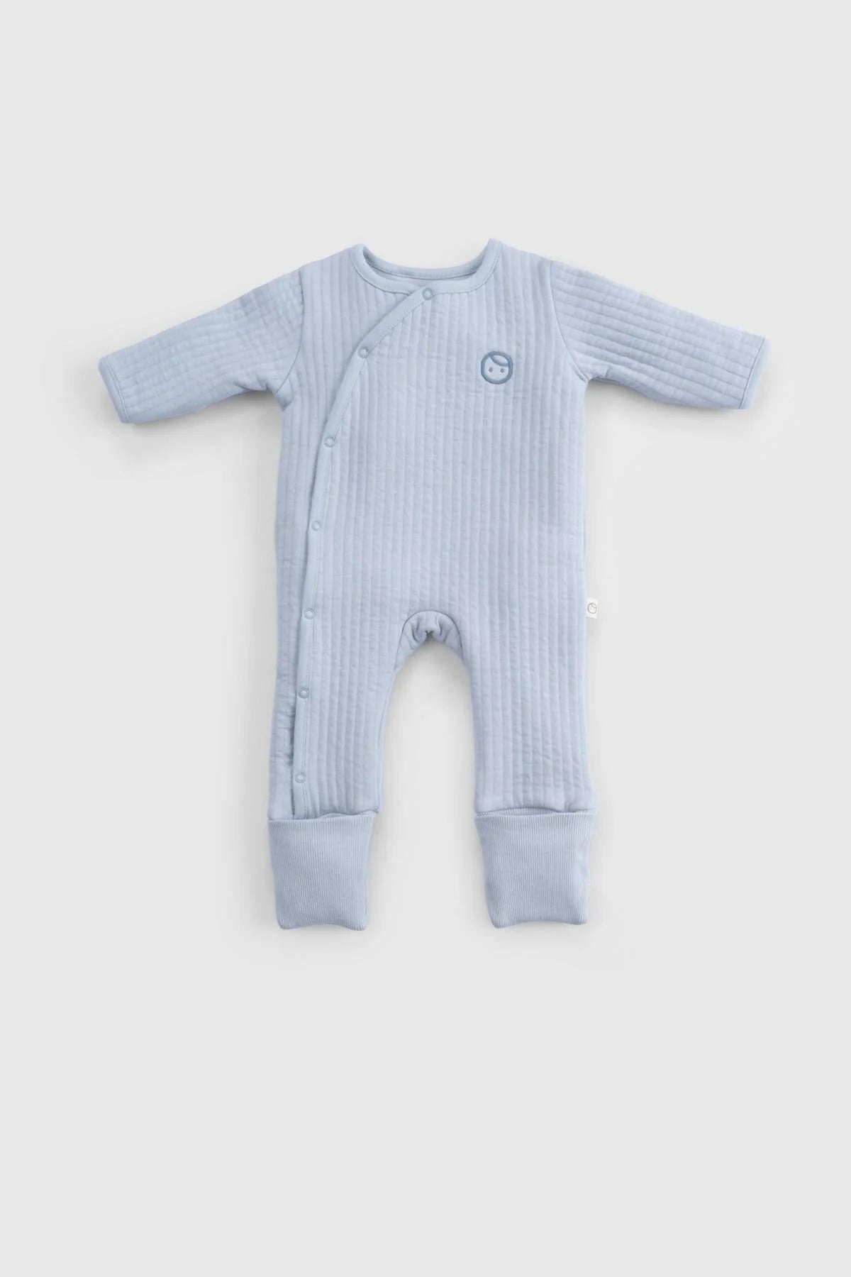 Organic cotton quilted sleepsuit in soft blue, designed for baby's warmth and comfort during the night.
