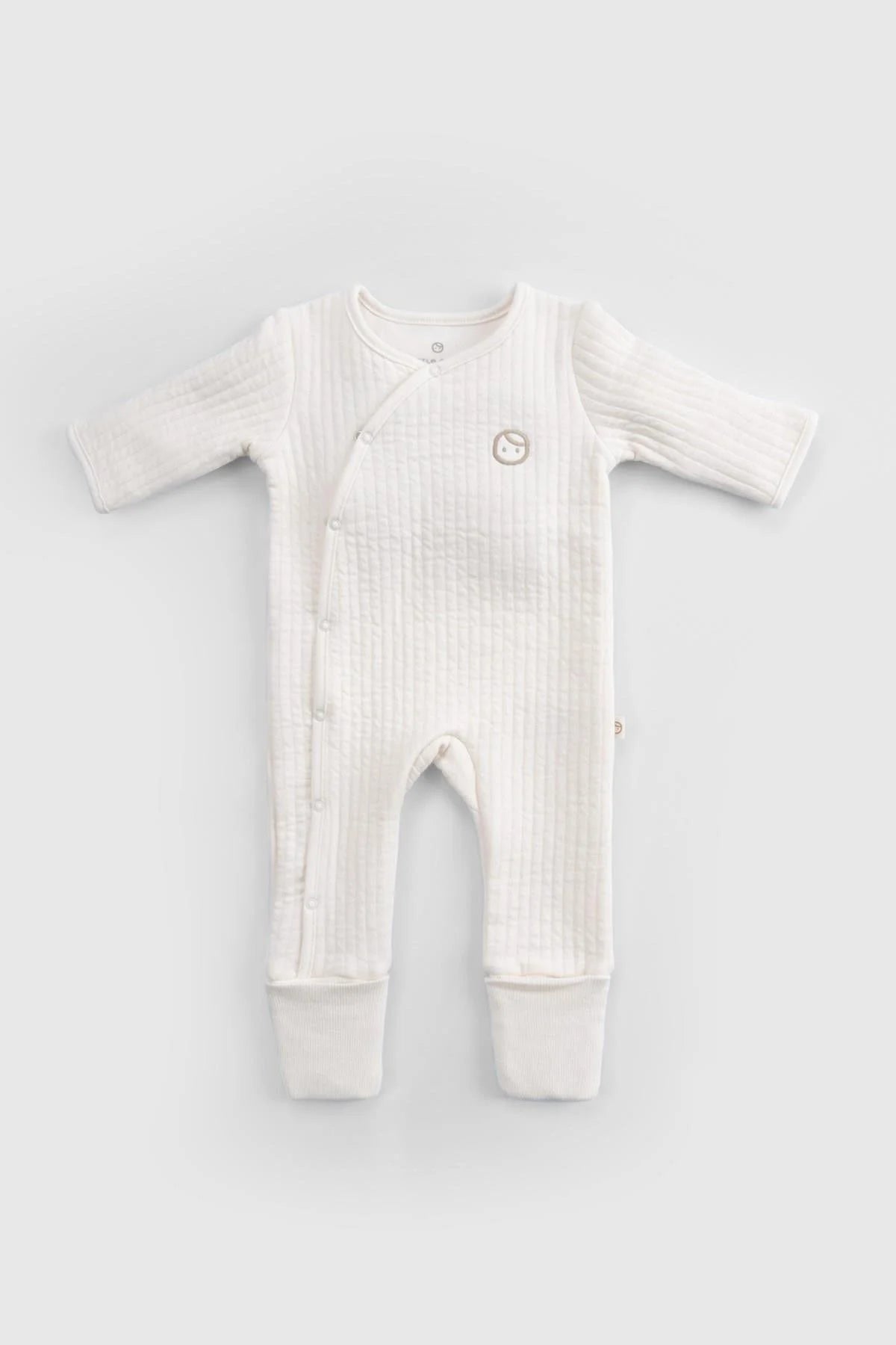 Organic cotton quilted sleepsuit in white designed for baby comfort with buttons and soft fabric.