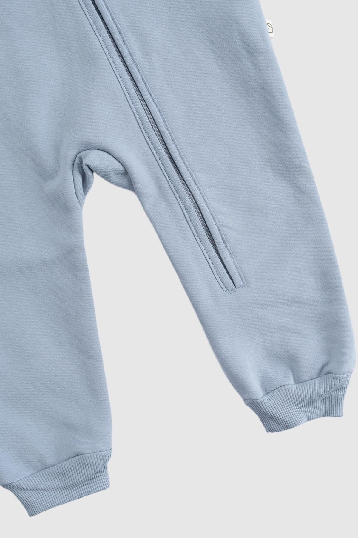 Close-up view of the blue organic cotton zipped onesie, featuring quilted fabric and ribbed cuffs, ideal for winter wear.